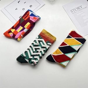 Three pairs of mid-calf socks with colorful geometric and oil painting patterns on white