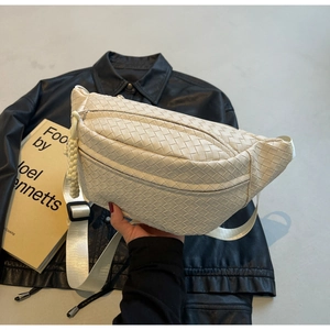 Detail of woven beige leather crossbody bag with wide shoulder strap and knotted zipper