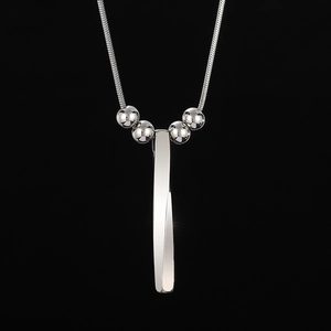 Detail of silver twisted bar pendant necklace with snake chain and metallic beads