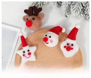 Close-up of handmade Christmas wool felt ornaments including Santa and reindeer on wooden tray
