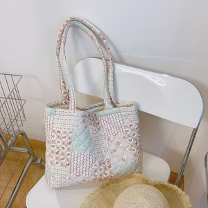 Détails du matelassage patchwork et motif floral sur un grand sac à bandoulière en coton