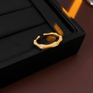 Detailed macro shot of a golden bamboo-shaped ring with zircon accents on jewelry box