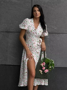 Detail of pink floral wrap dress featuring bubble sleeves and soft cotton texture