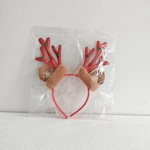 Close-up of red glitter reindeer antlers with brown fur ears in plastic packaging