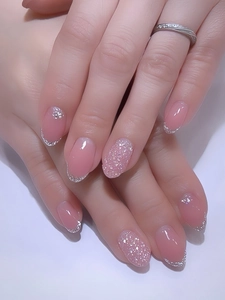 Detailed view of pink long oval press-on nails with silver glitter french tips and sparkles