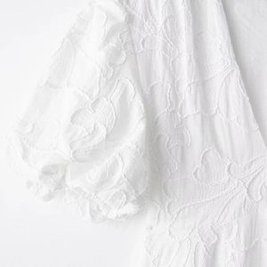 White mini dress with V-neck puff sleeves and detailed floral jacquard embroidery
