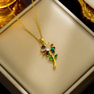 Collana con ciondolo a girasole dorato e zirconi colorati in una scatola regalo