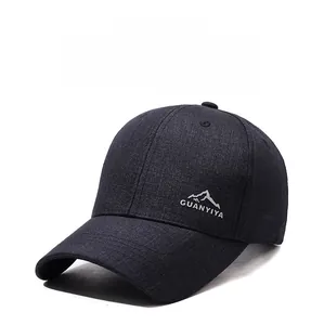 Detailed view of mountain peak embroidery and brand logo on a dark grey outdoor baseball cap