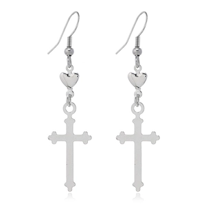 Vue détaillée de boucles d'oreilles cœur et croix argentées sur fond blanc avec reflet