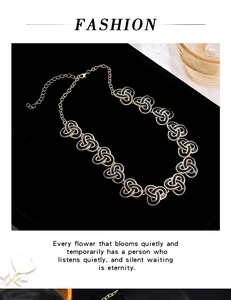 Detail view of a vintage style gold and black metal chain necklace on a tray