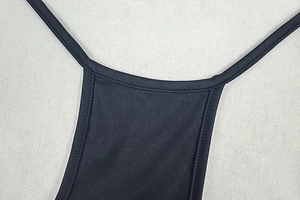 Detailed close-up of neckline and straps on a black backless stretch jumpsuit