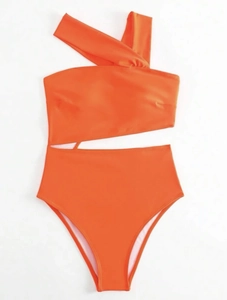 Close-up of bright orange one-shoulder cutout swimsuit with premium textured fabric