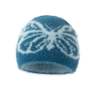 Detail of teal knit beanie featuring fluffy faux mink fur and white butterfly jacquard pattern