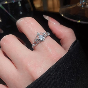 Close-up of a silver crown ring with zircon stones worn on finger in elegant setting