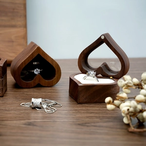 Detail of heart-shaped walnut ring box with white sponge lining and dried flowers