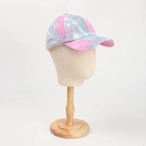 Side view of distressed pink and grey tie-dye baseball cap on wooden mannequin head