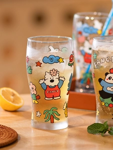 Detail view of a large glass with cute cartoon animal prints and cold iced drink inside