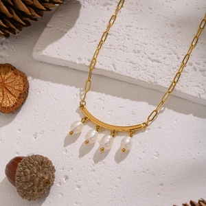 Vue détaillée du collier en acier inoxydable doré avec barre incurvée et cinq perles d'eau