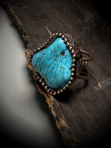 Macro shot of an irregular turquoise stone set in a vintage bronze beaded open ring