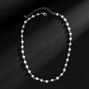Detail of silver necklace with white faux pearls, crystal balls, and lobster clasp closure