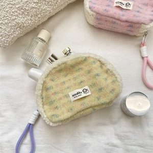 Detail of plush shell cosmetic bag featuring polka dot pattern and lamb wool trim