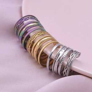 Set of colorful, gold, and silver 304 stainless steel geometric rings on a ceramic plate