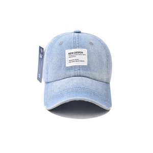 Close-up of light blue washed denim baseball cap featuring white fabric patch and tag