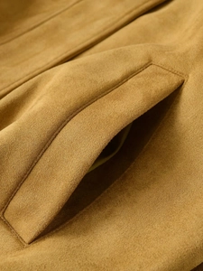 Detailed close-up of the ginger suede bomber jacket showing pocket stitching and texture