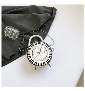 Detailed top view of a piano keyboard and clock face round bag with chain strap