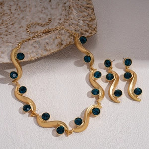Vintage gold wavy S-shape jewelry set with deep blue gems and matching earrings