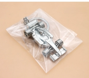 Detailed view of silver metal F1 racing car keychain inside clear OPP bag packaging