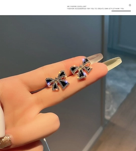 Macro view of S925 silver bow stud earrings with black stones and sparkling rhinestones