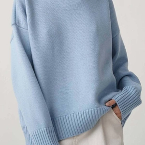 Détail du pull en tricot bleu clair montrant les épaules tombantes et la texture côtelée