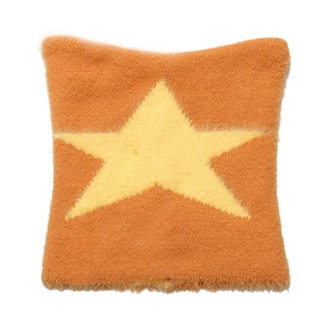 Detail of plush orange knit fabric featuring a fuzzy yellow star pattern texture