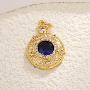 Close-up of gold-plated celestial pendant with blue gemstone and star engravings