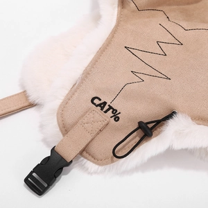Detail of camel suede aviator hat showing thick white faux fur lining and buckle