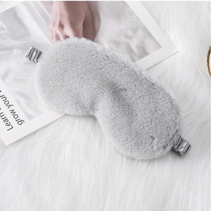 Close-up of a plush grey sleep mask with soft faux rabbit fur and silk elastic band