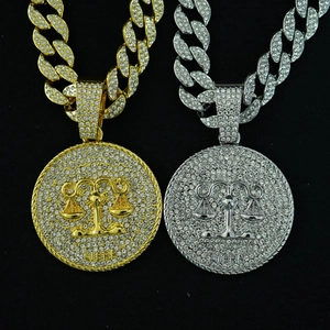 Detailed close-up of gold and silver iced-out Libra zodiac pendant necklaces with crystals