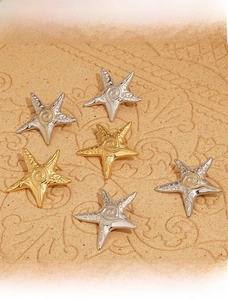 Detailed view of starfish earrings in gold, silver and mixed tones with spiral texture