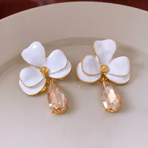 Boucles d'oreilles fleurs en émail blanc avec gouttes en cristal champagne sur céramique
