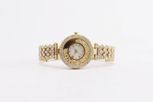 Detailed macro of gold watch featuring sparkling rhinestones and floating dial stones