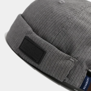 Gray textured twill docker hat with leather patch and blue woven label in street style