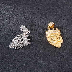 Detailed view of silver and gold lion head pendants featuring crystal crown settings