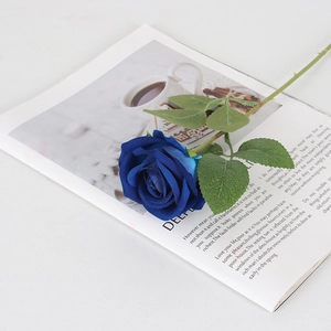 Rosa artificial de terciopelo azul marino sobre un libro para decoración de interiores