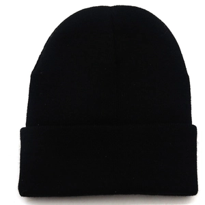Détail de la texture en maille acrylique noire et revers classique du bonnet d'hiver doux