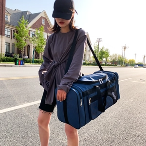 Blue large capacity oxford travel bag shown being worn by a model on a street