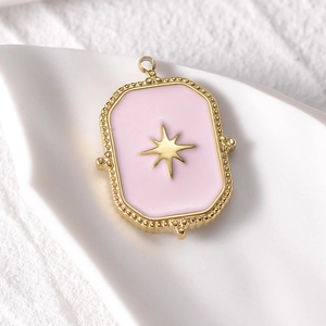 Gold rectangular 14k pendant with pink enamel star and beaded edges on white plate