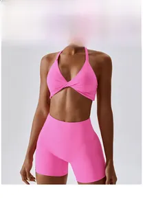 Detail of neon pink yoga set featuring a halter twist sports bra and high-waisted shorts