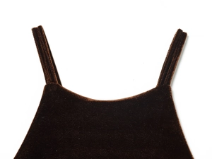 Détail du tissu en velours marron foncé avec fines bretelles et texture douce de luxe