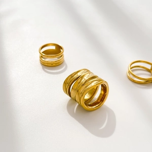 Macro detail of multi-layered 18K gold plated braided rings with knot design